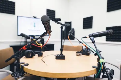 the towncast studios recording room, outfitted with a table, 4 chairs, microphones, and headphones